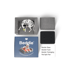 Overhead view of Beddie pet bed components including the base, foam, packaging box, and red light therapy pad with a Dalmatian dog